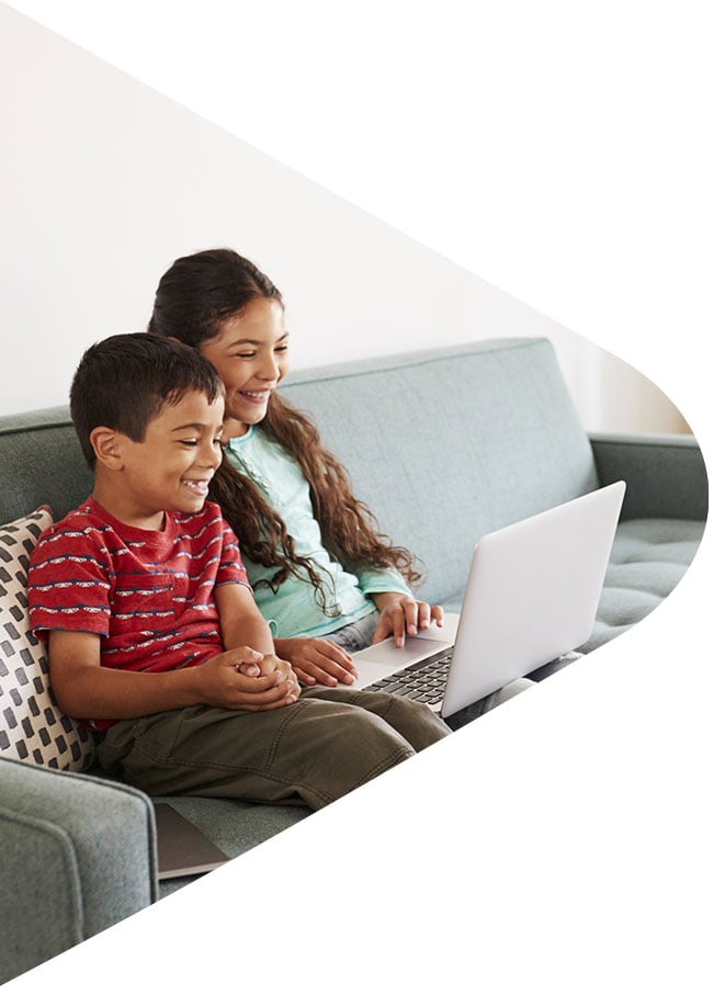 Kids on the couch watching video on laptop